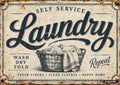 Vintage sign with "SELF SERVICE Laundry" above a laundry basket full of clothes, and "WASH DRY FOLD Repeat" text.